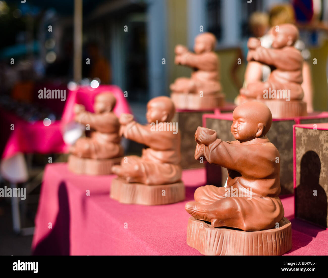 Pottery Buddhas for sale in a French country market Stock Photo