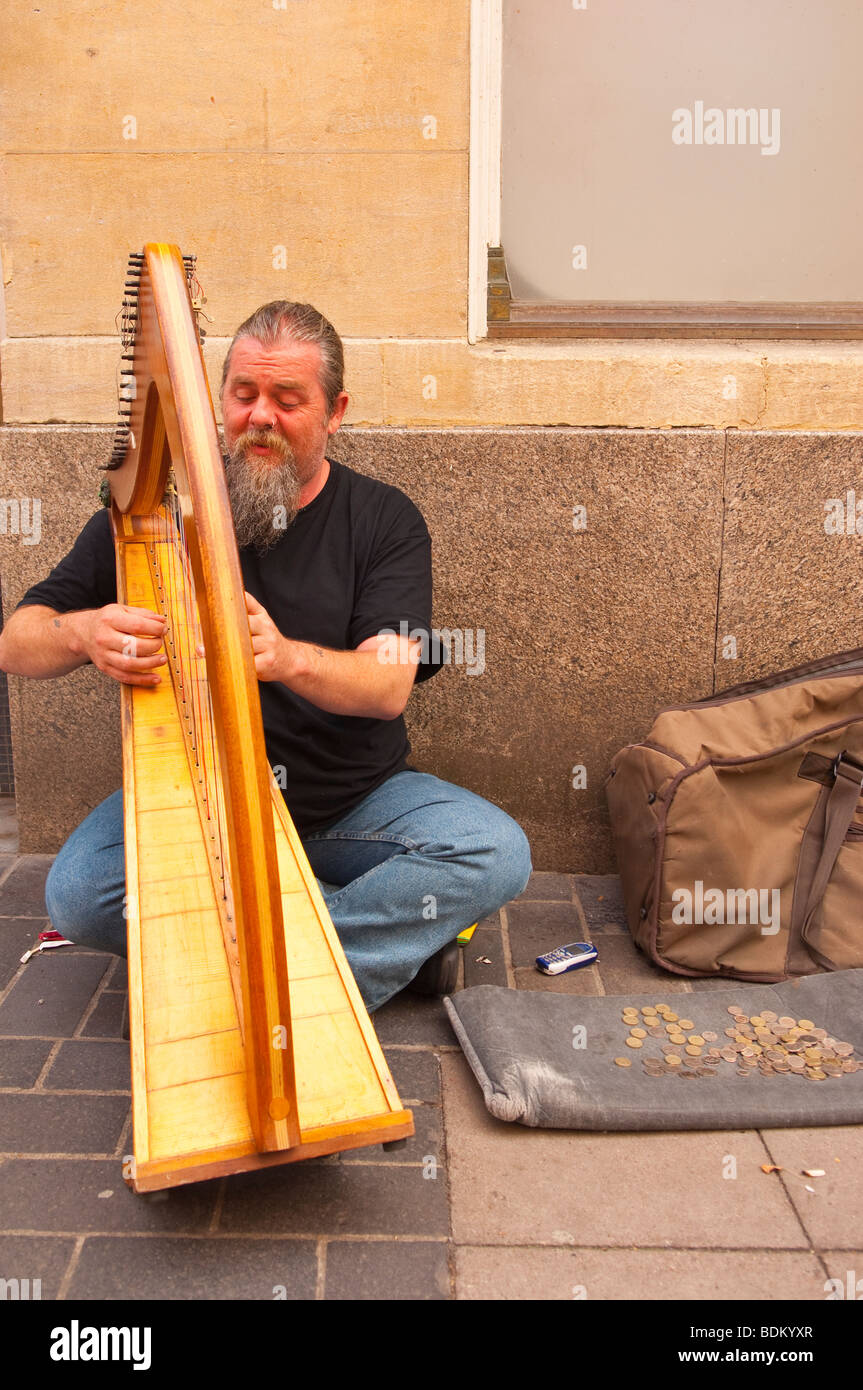 A man busker playing the harp busking for money in Norwich Norfolk Uk Stock Photo