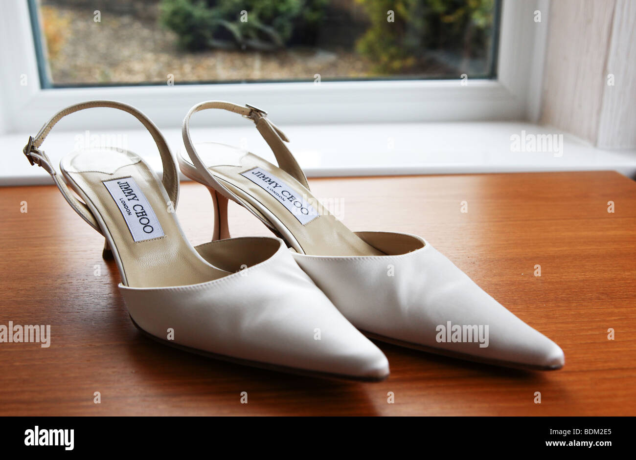 Luxury expensive white cream bridal wedding shoes on wedding day popular designer brand UK Stock Photo
