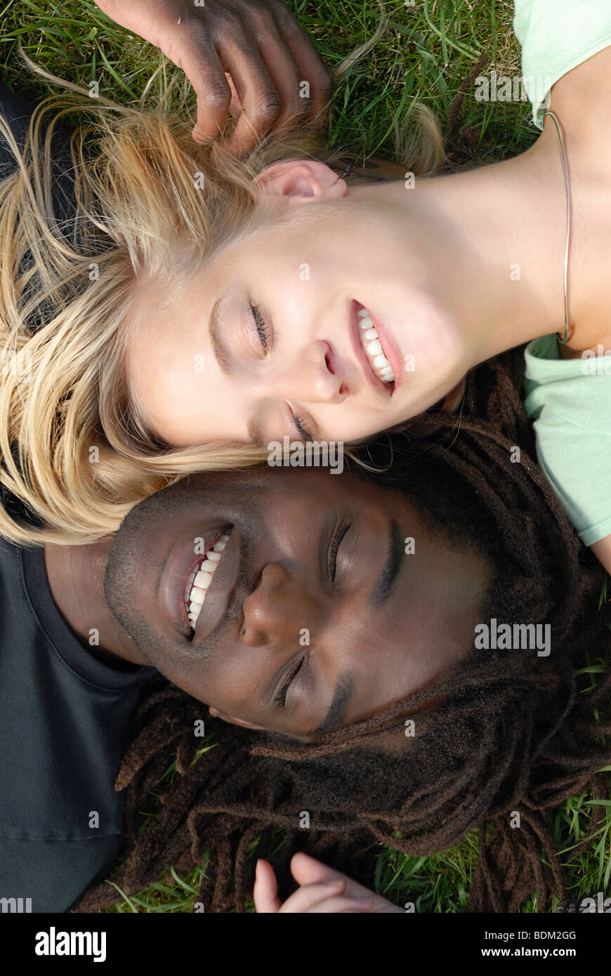 young multi-ethnic couple lying in the grass Stock Photo - Alamy