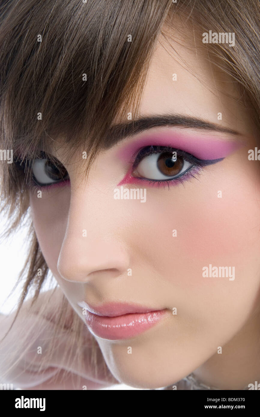 Close up beauty portrait of a young woman with extravagant pink eye makeup Stock Photo