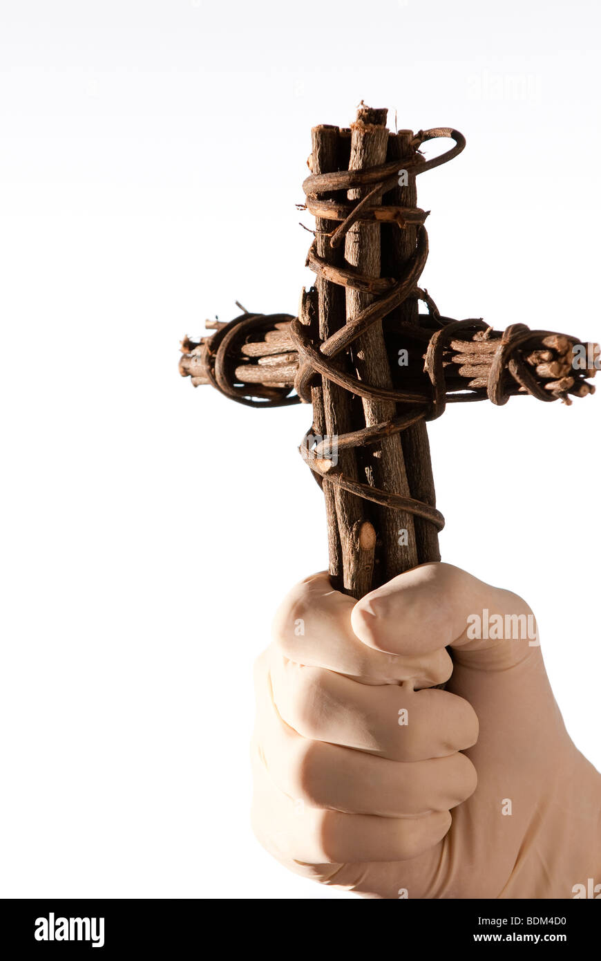 Hand in medical glove holding a wooden cross Stock Photo