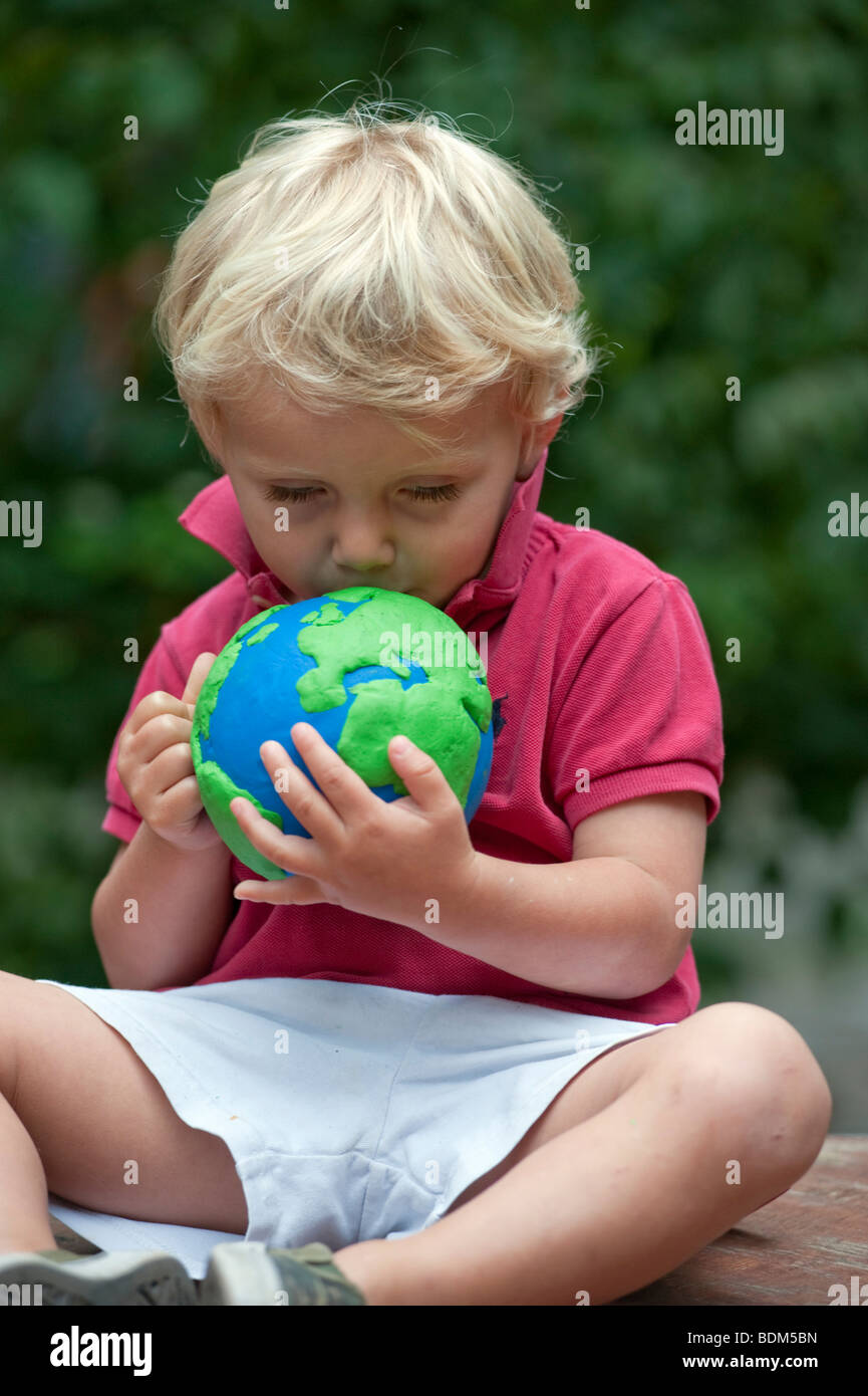 Young boy cuddling and holding a model of planet Earth Stock Photo