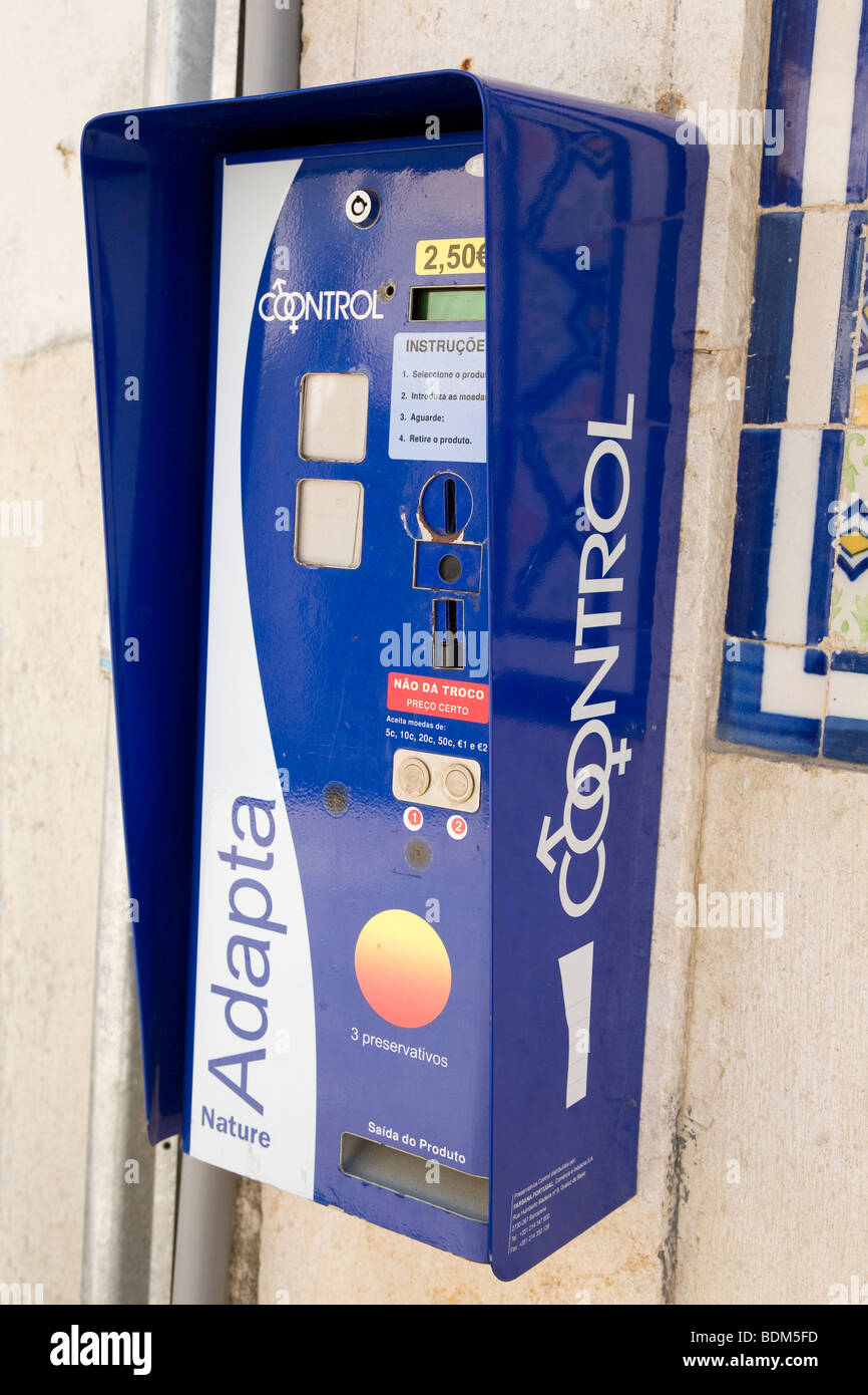 A condom vending machine hangs on a wall in a street in Portugal Stock