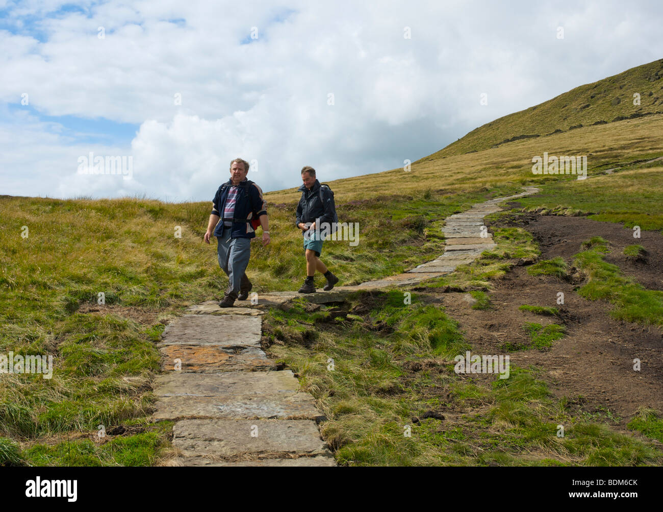 Two walkers on new flagged section of the Pennine Way path, Kinder Scout, near Edale, Peak National Park, Derbyshire, England UK Stock Photo