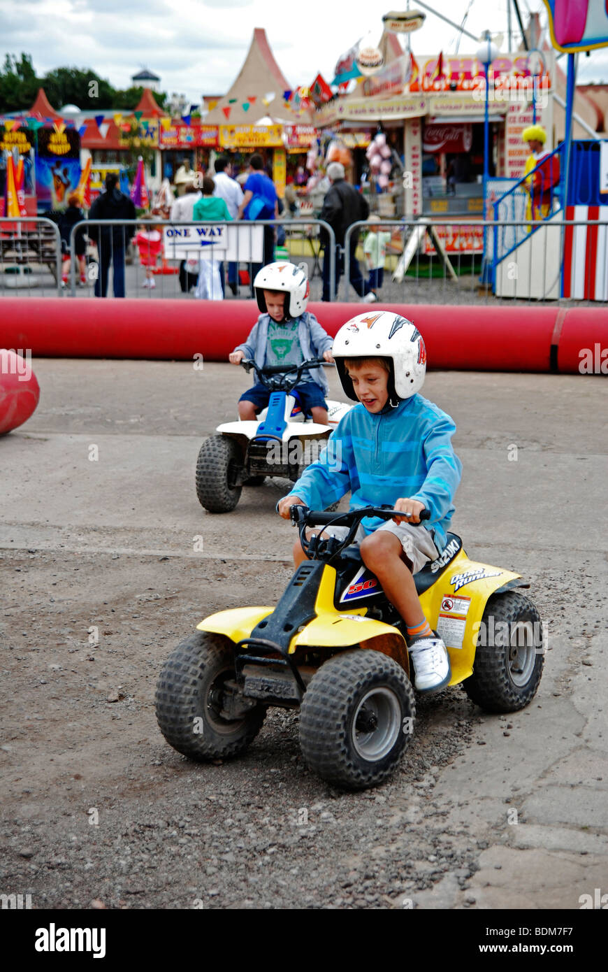 little boys riding quad bikes at the funfair in southport,lancashire,uk Stock Photo