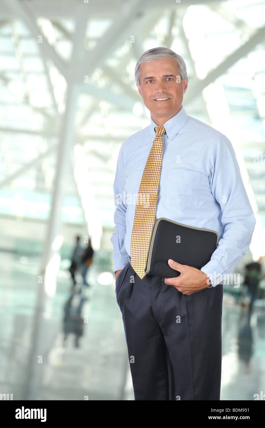 Man In Building Smiling Businessman Standing in Building Lobby with notebook and hand ...