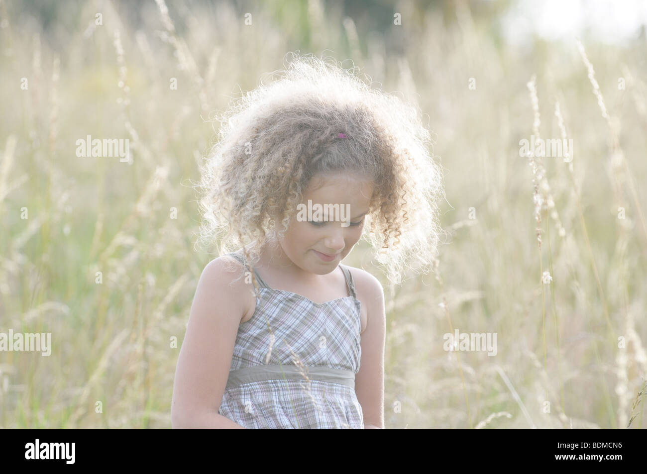 A beautiful young girl standing in a field of tall grass Stock Photo ...