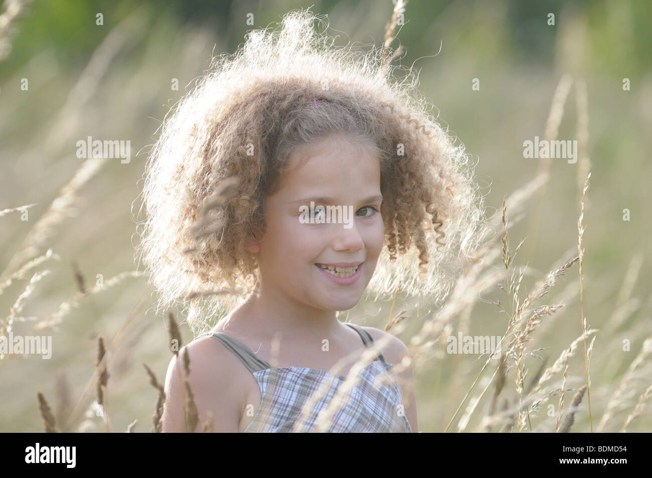 A beautiful young girl standing in a field of tall grass Stock Photo ...