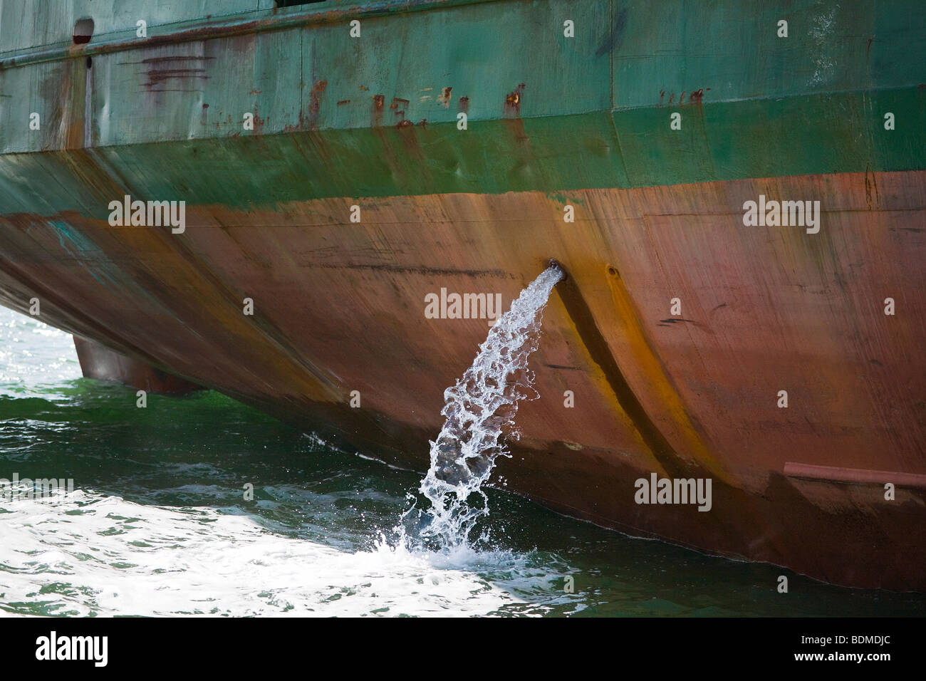 Cargo ship emptying tanks in harbour. UK. Stock Photo