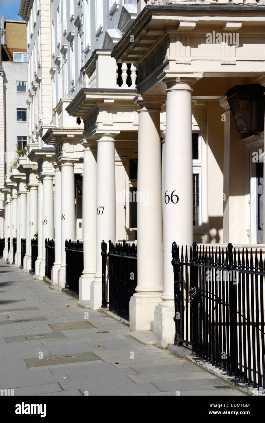 Numbered stone columns outside elegant Victorian terraced houses in Eccleston Square, Victoria, London, England Stock Photo