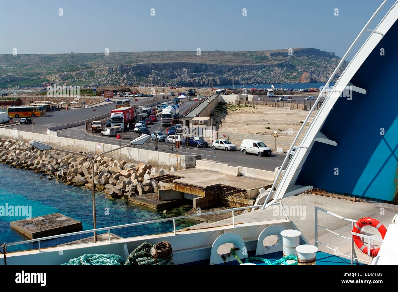 Vehicles wait to board the ferry to Gozo at Malta's Cirkewwa ferry terminal. Stock Photo