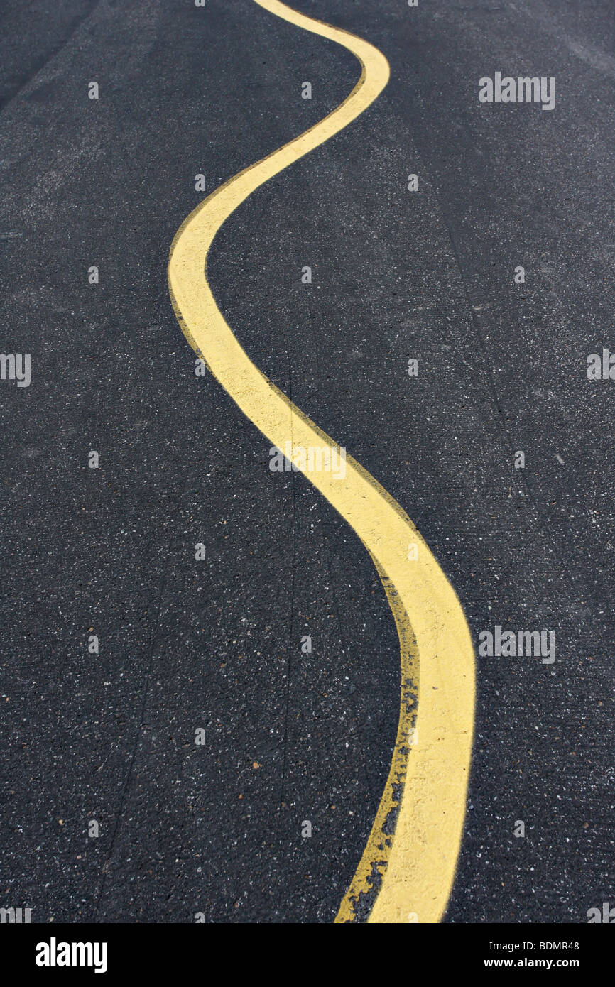 Curving yellow line on the pavement Stock Photo - Alamy