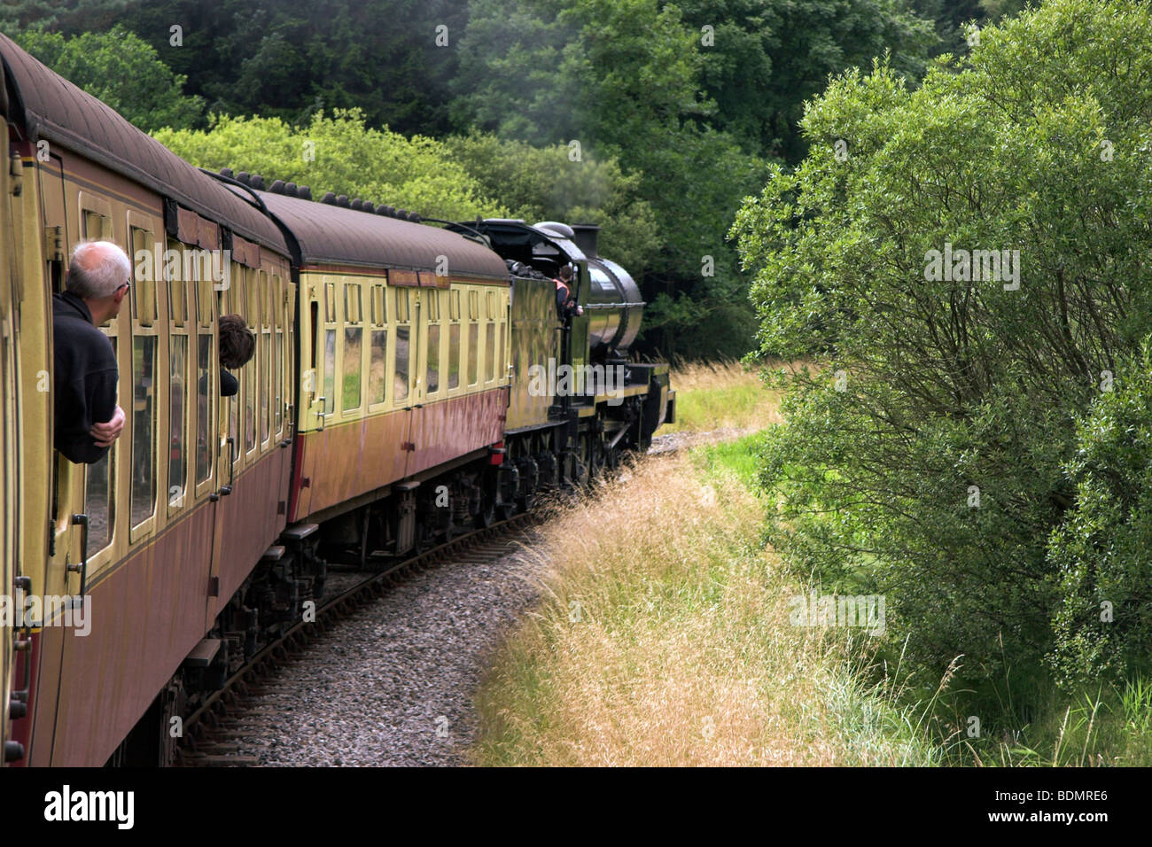 NYMR, Passengers leaning out of the window of a moving steam train, North York Moors Railway, North Yorkshire, England UK Stock Photo