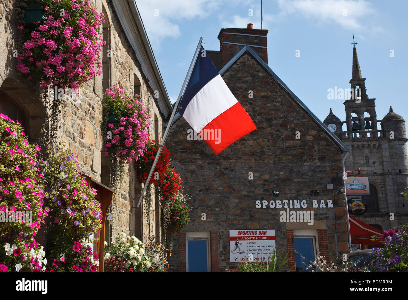 French flag and hanging baskets on the Mairie (town hall) at Lézardrieux, Brittany, France Stock Photo