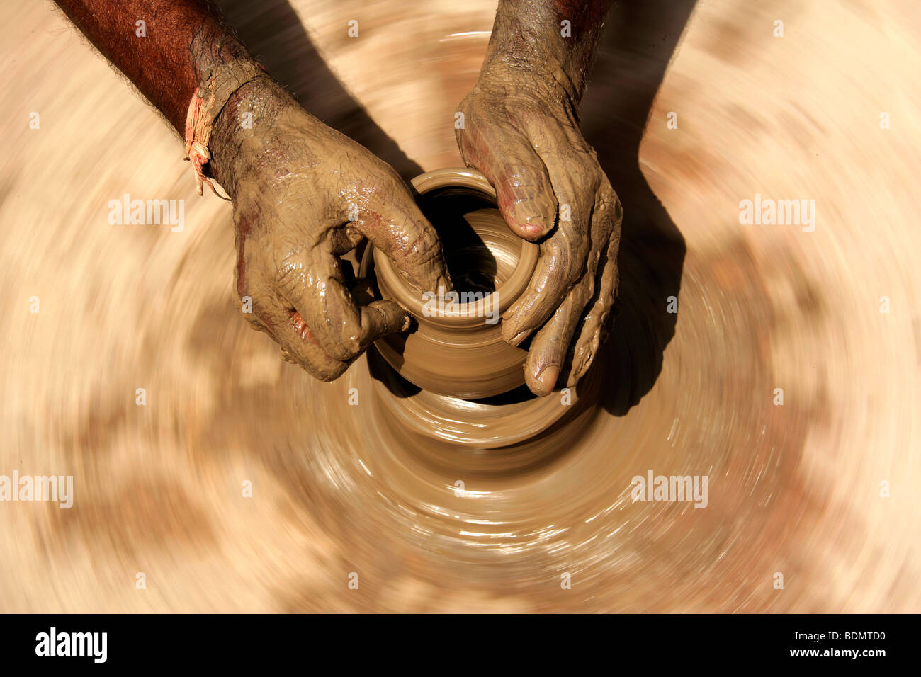 Hands of a potter, 58, in Dunjarpur, forming a piece of pottery on the potter's wheel, Rajasthan, India, Asia Stock Photo