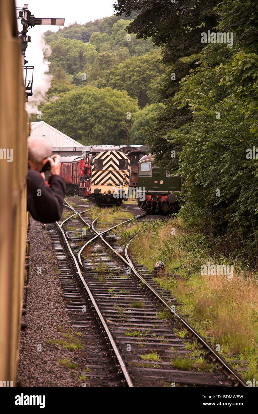 NYMR, man photographing trains from a moving steam train, North York Moors Railway, North Yorkshire, England UK Stock Photo