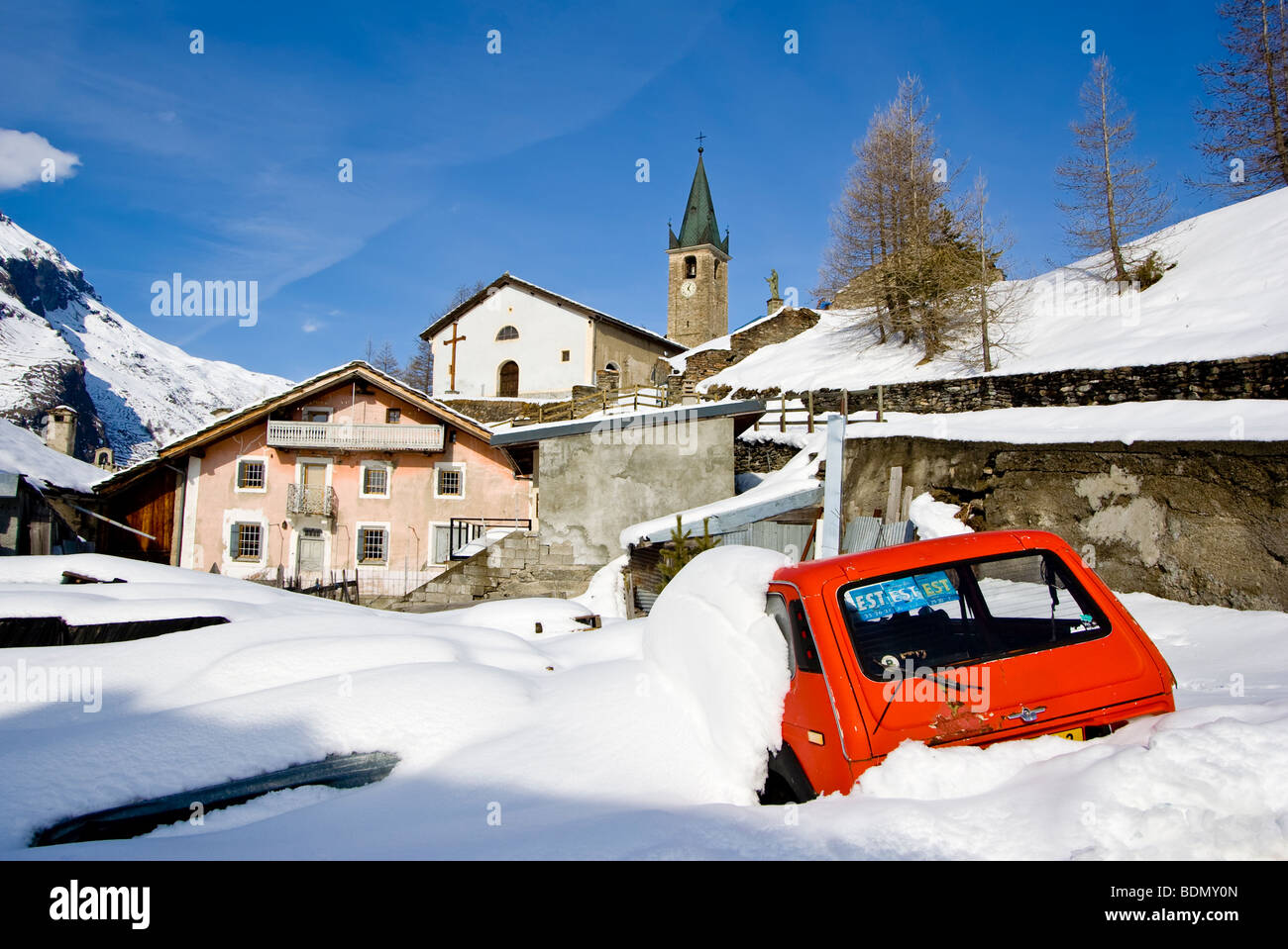 Red Car stuck in snow in french village Bessans France Stock Photo