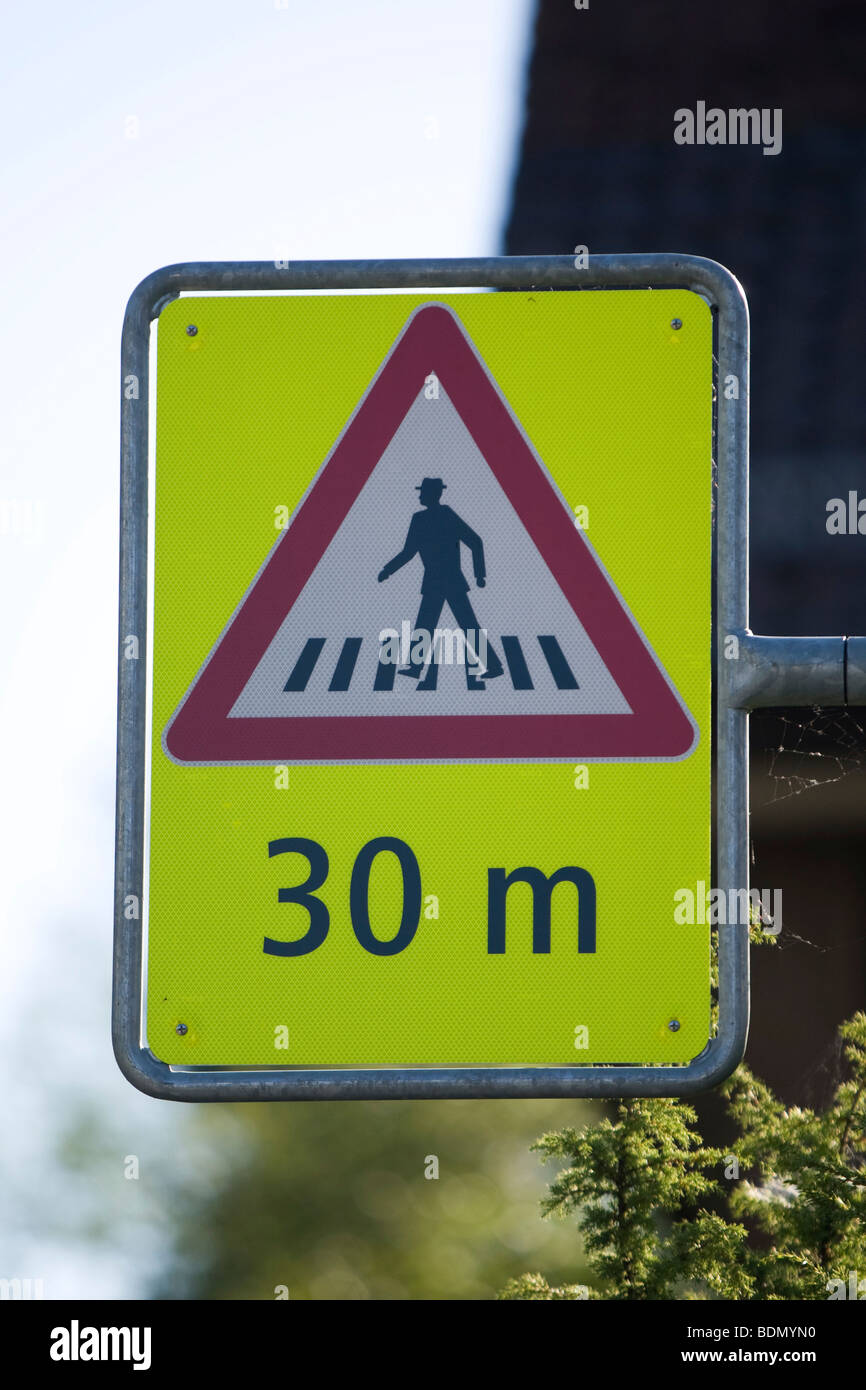 Bright yellow road sign, attention, pedestrian crossing in 30 meters Stock Photo