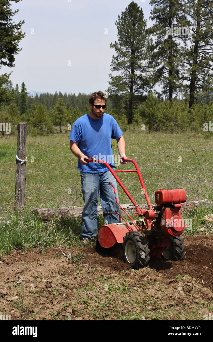 Man rototilling the ground, getting it ready for a garden. Stock Photo