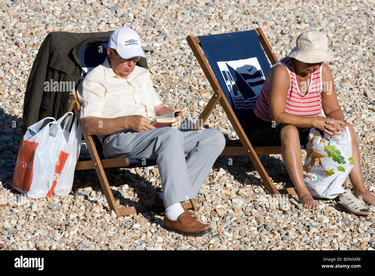 A couple of holiday makers on the beach at Eastbourne, England. Stock Photo