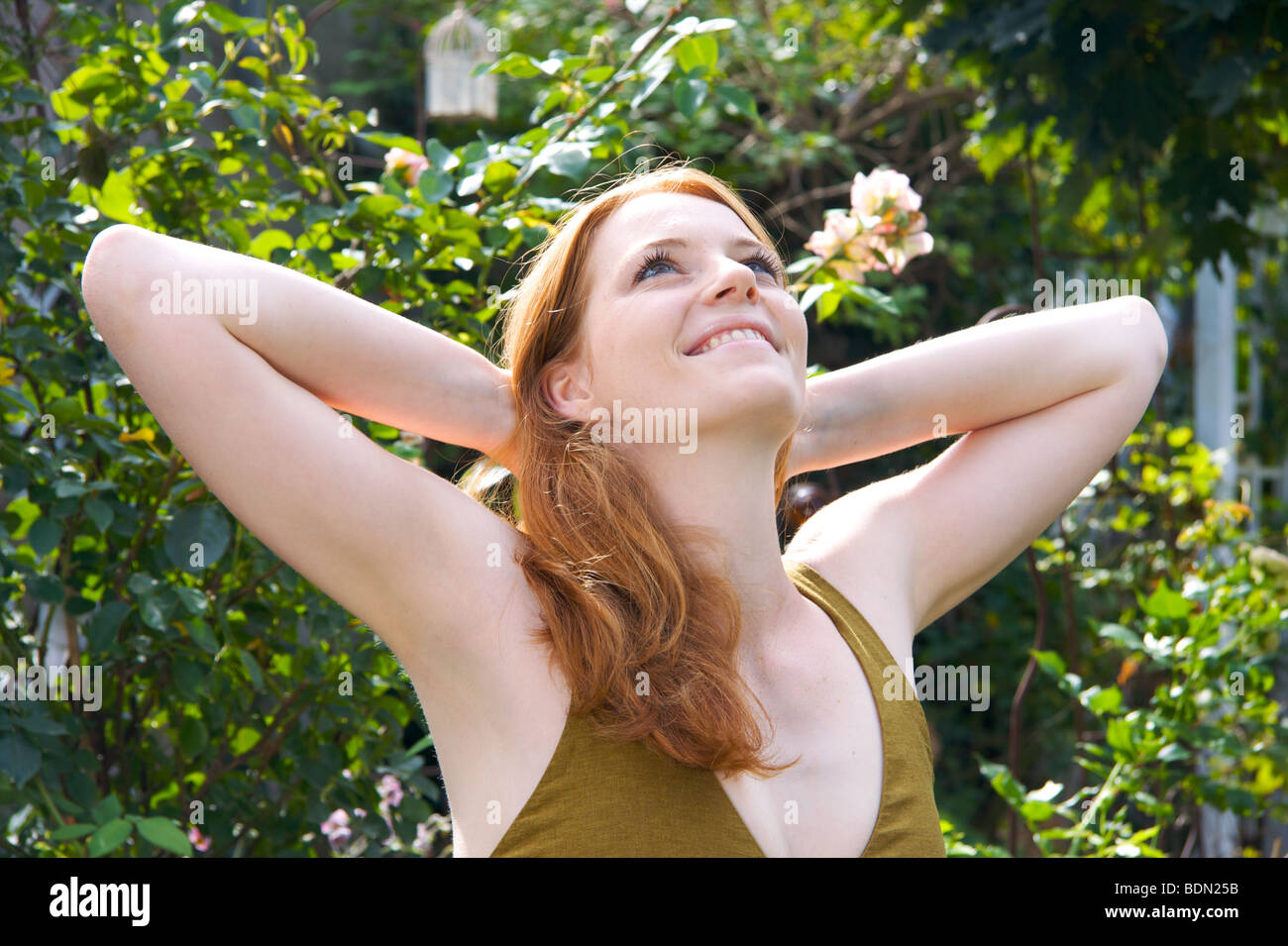 Young woman relaxing into a garden Stock Photo