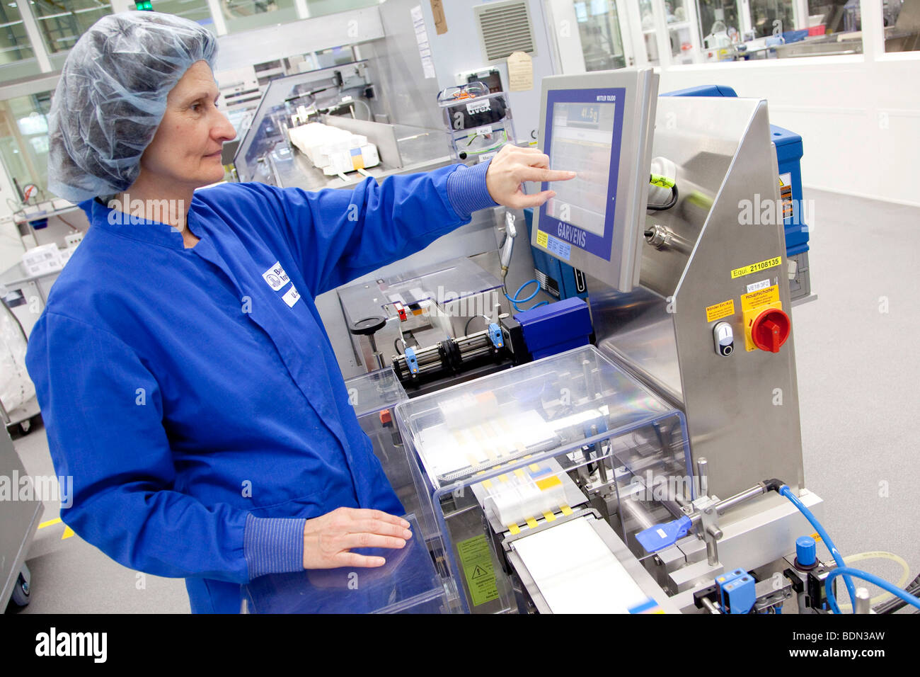 Employee of Boehringer Ingelheim GmbH, checking a packaging machine in the logistics and packaging center, pharmaceutical compa Stock Photo