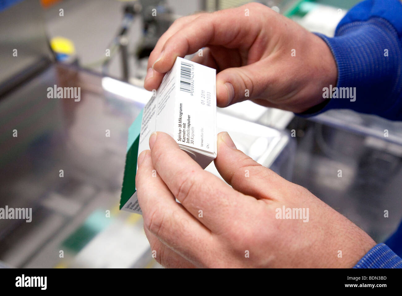 Employee of Boehringer Ingelheim GmbH checking a respiratory drug from a packaging machine in the logistics and packaging cente Stock Photo