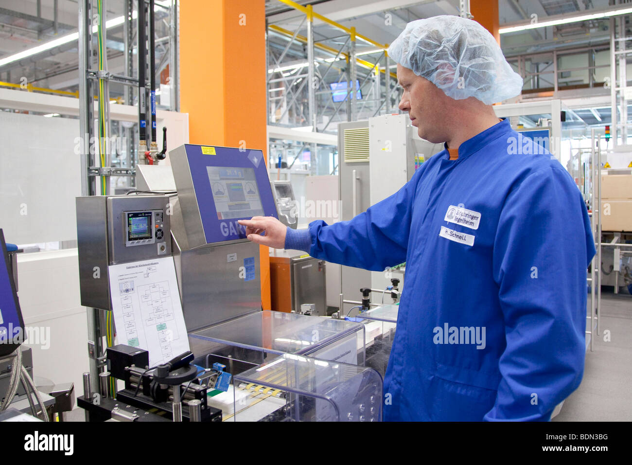 Employee of Boehringer Ingelheim GmbH, checking a packaging machine in the logistics and packaging center, pharmaceutical compa Stock Photo