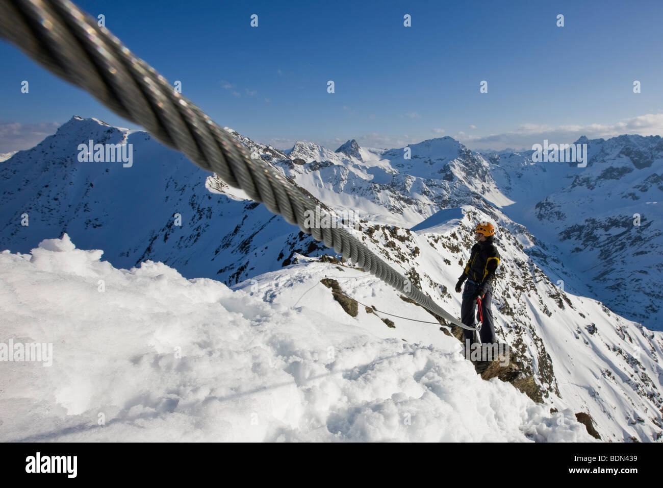 Secured climber on a fixed rope route in the high mountains in winter, Arlberg, Verwallgruppe mountain range, North Tyrol, Tyro Stock Photo
