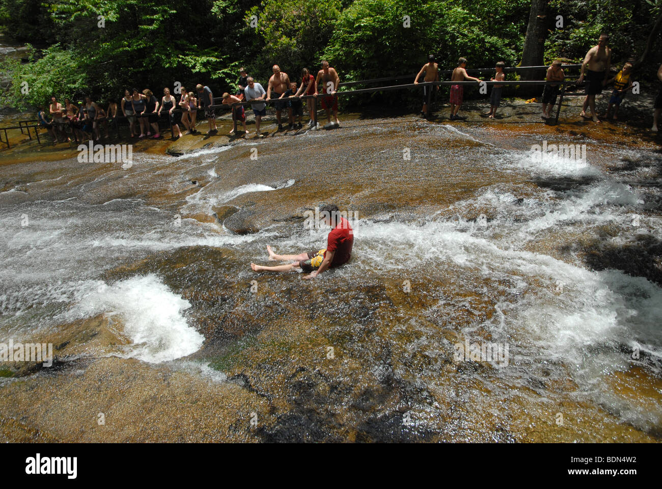 A young boy slides down a flat rock water slide in North Carolina. Stock Photo