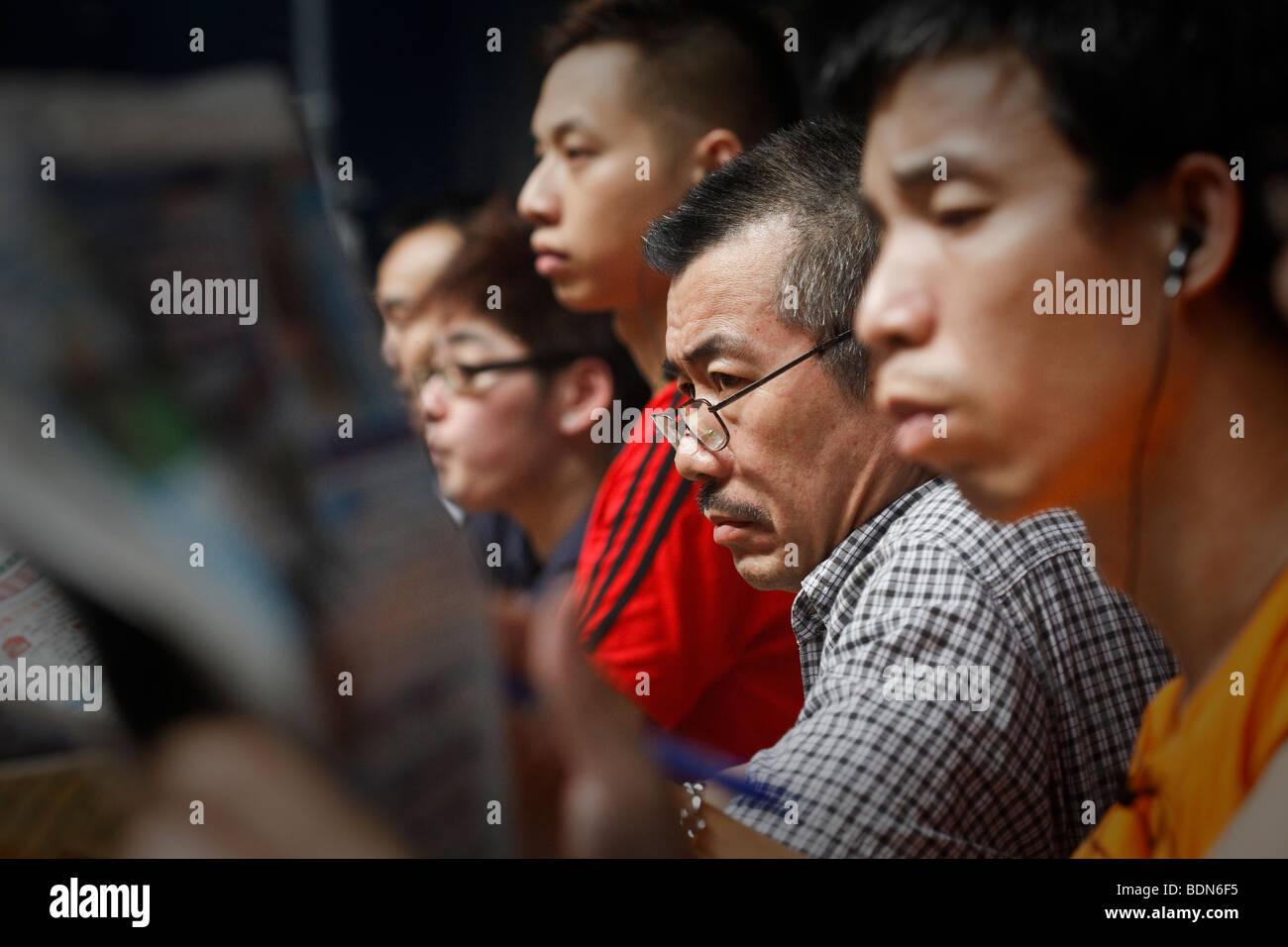 Punters study the race form at a night horse racing event at the Happy Valley race course in Hong Kong. Stock Photo