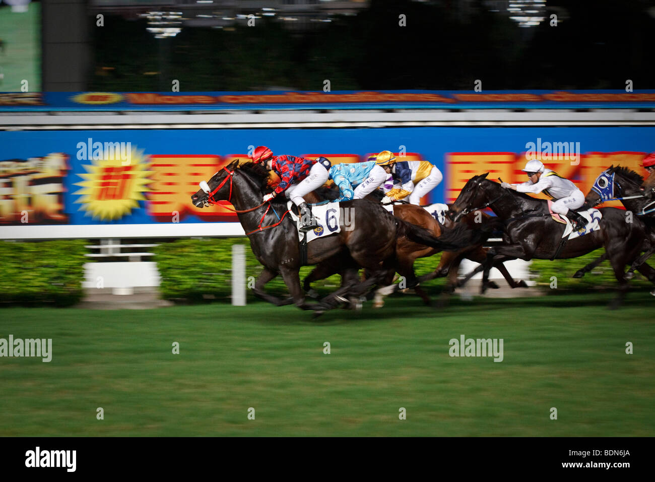 A final gallop to the finish at a night horse racing event at Happy Valley race course in Hong Kong. Stock Photo