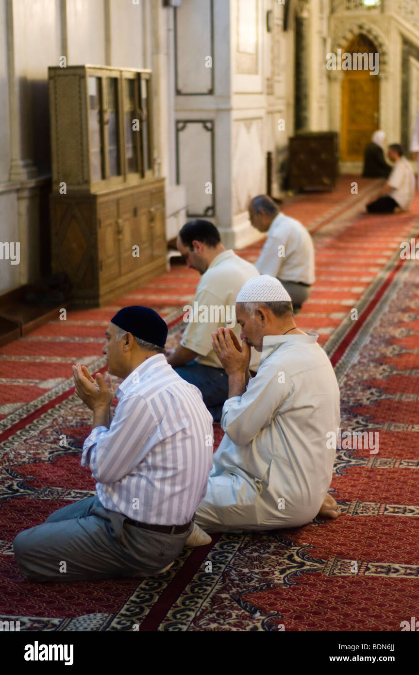 Men pray in the Umayyad Mosque (Grand Mosque of Damascus). Stock Photo