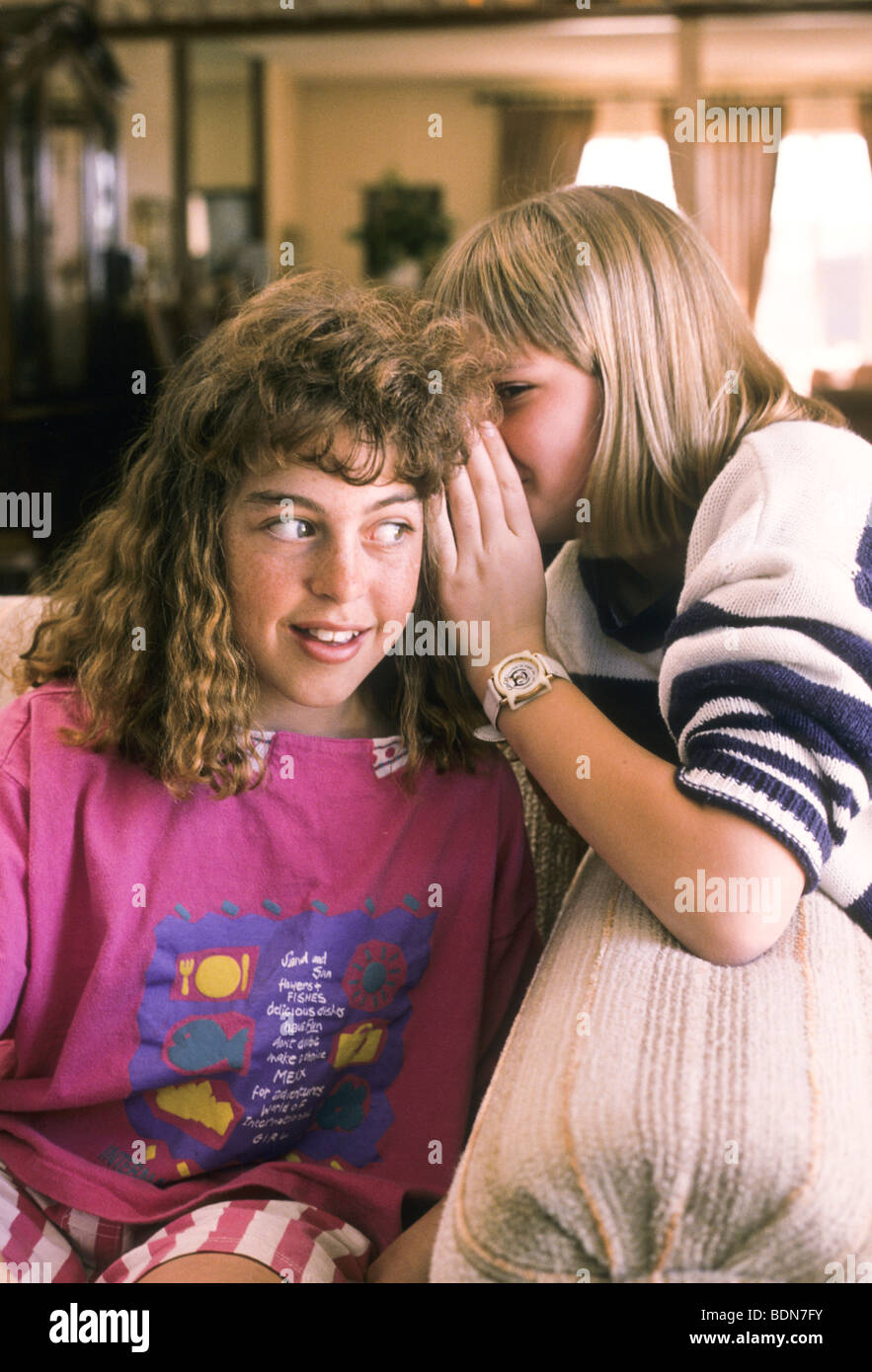 pre-teen teen female blond confide talk whisper share support Stock Photo