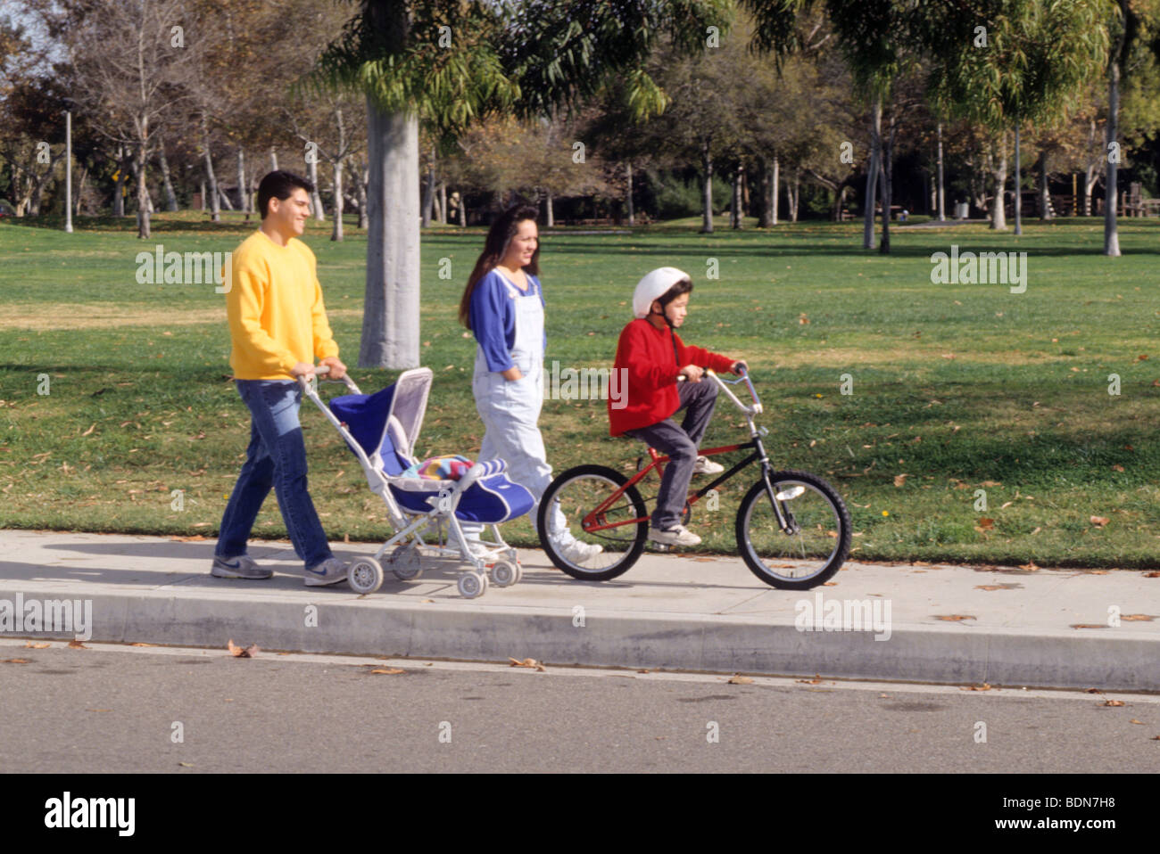 Latin family enjoy sun fresh air sidewalk exercise bicycle safety