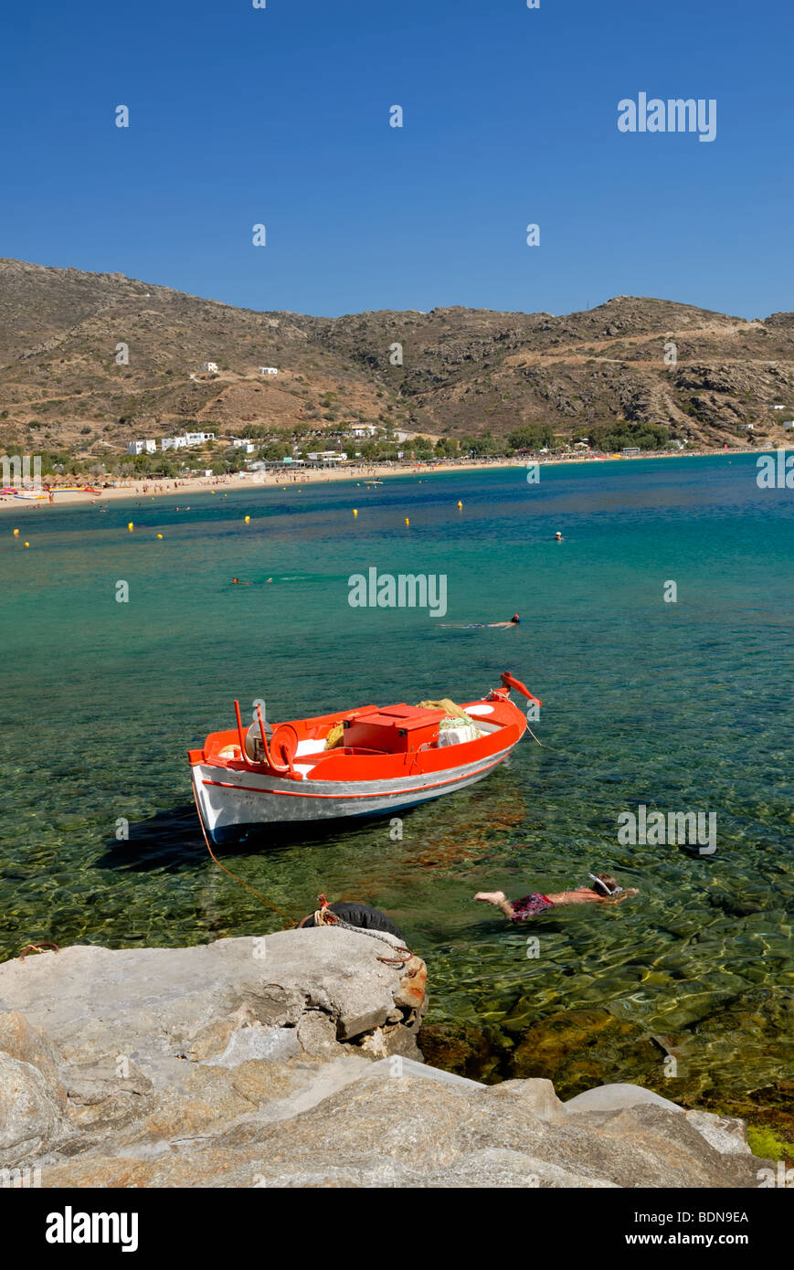 Children are snorkling near the fishing boat pier in the Mylopotas beach, one of the best beaches to be found anywhere in Greece Stock Photo