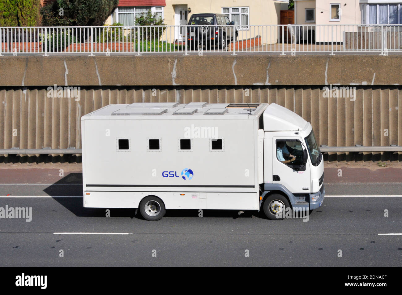 GSL prisoner delivery van on A12 dual carriageway passing semi detached houses Stock Photo
