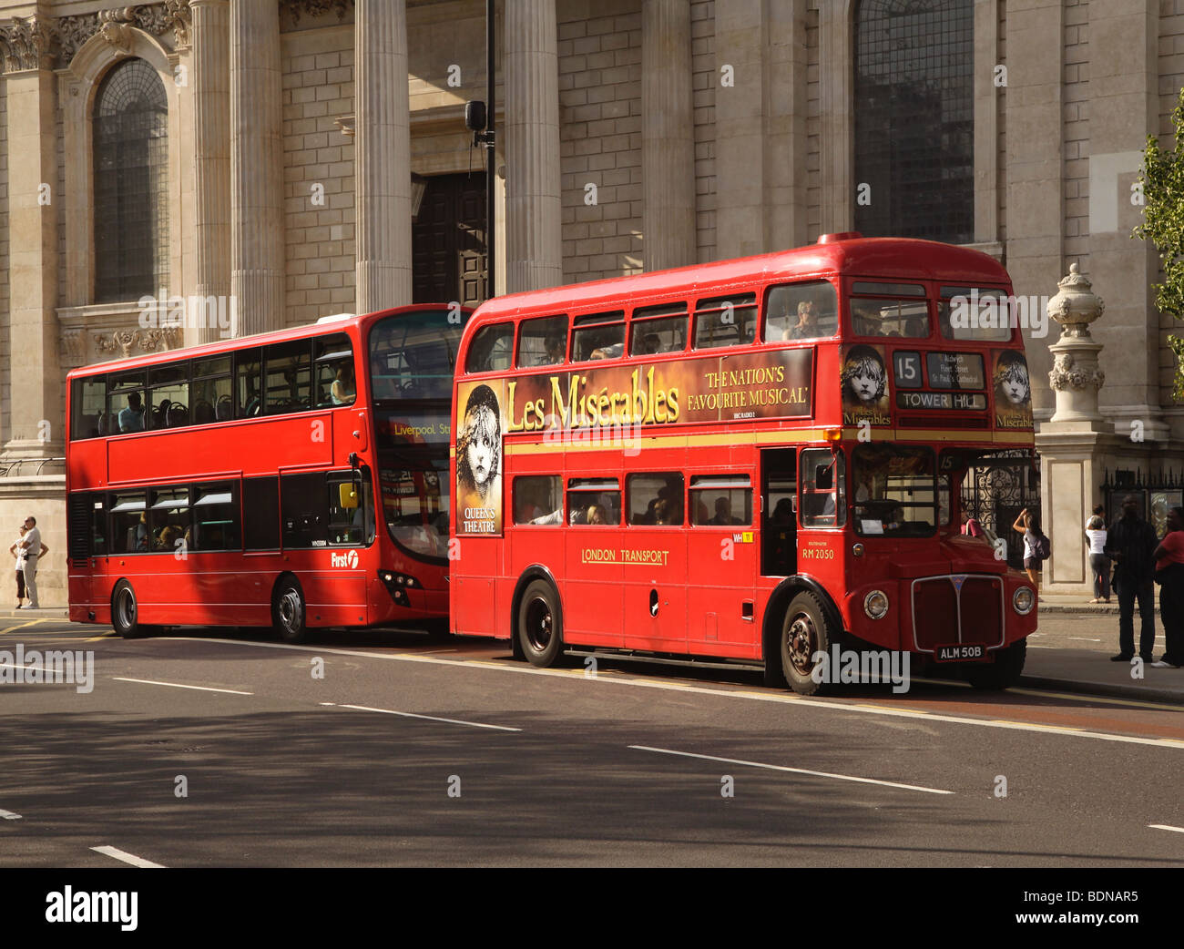 Two London buses stopped at the bus stop picking up passengers Stock Photo