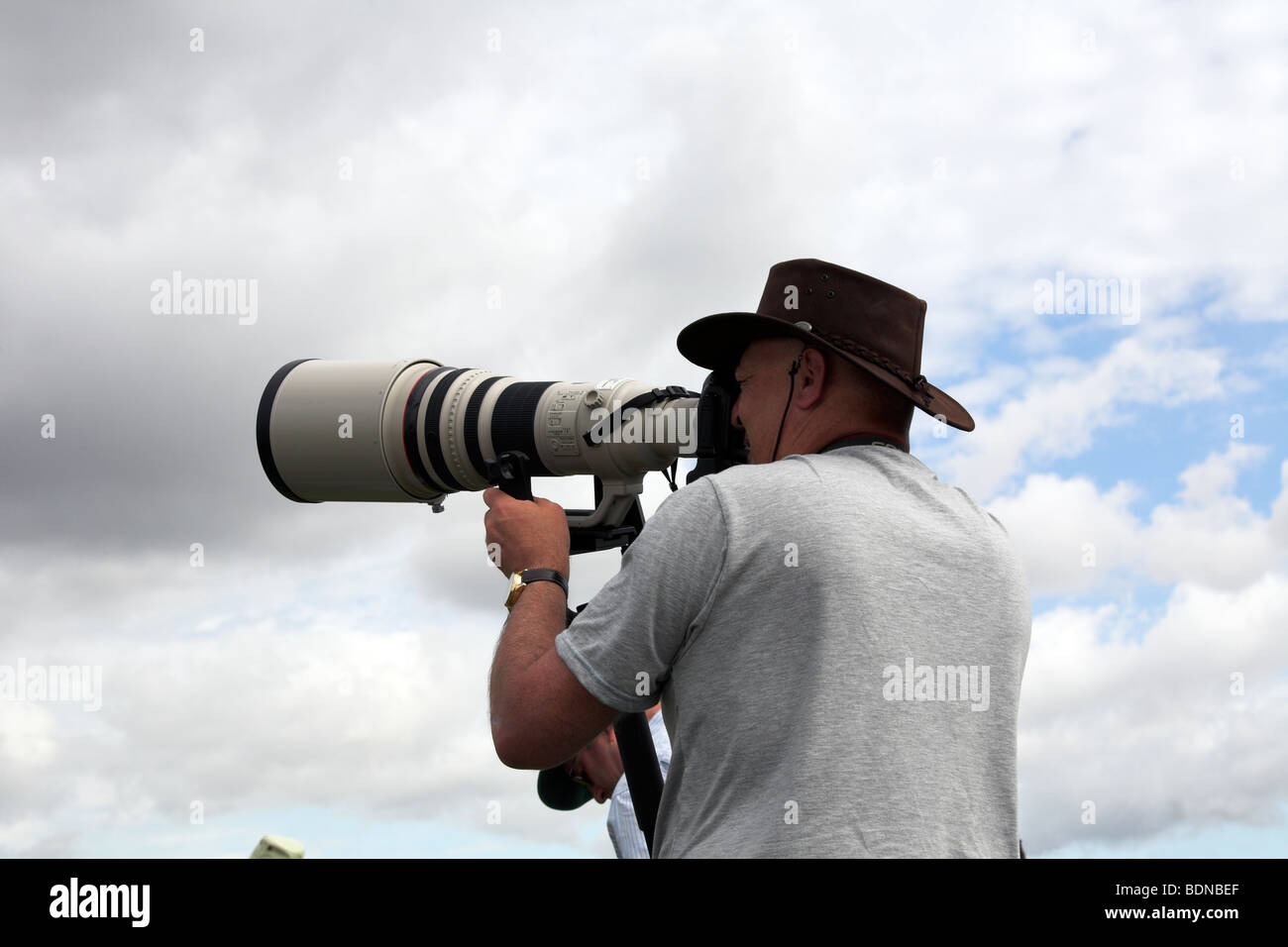 Photographer with a large telephoto lens Stock Photo