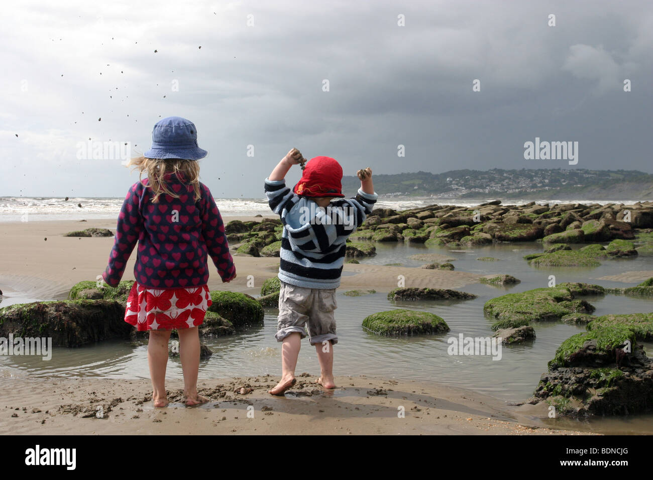 Kids playing in the rock pools at Charmouth beach, Dorset Stock Photo