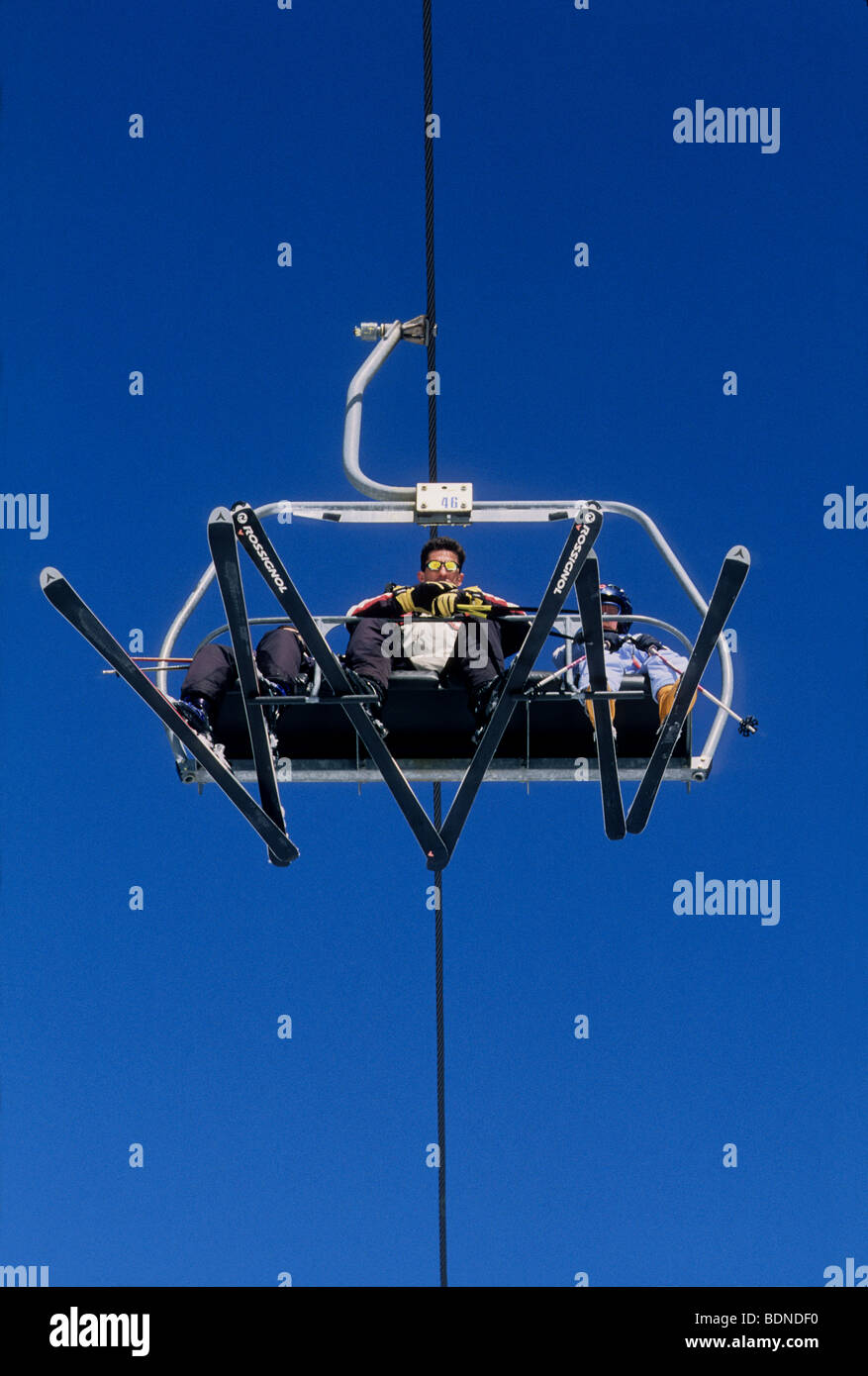 Skiers in a remote lift chair in the station of LA Colmiane Stock Photo