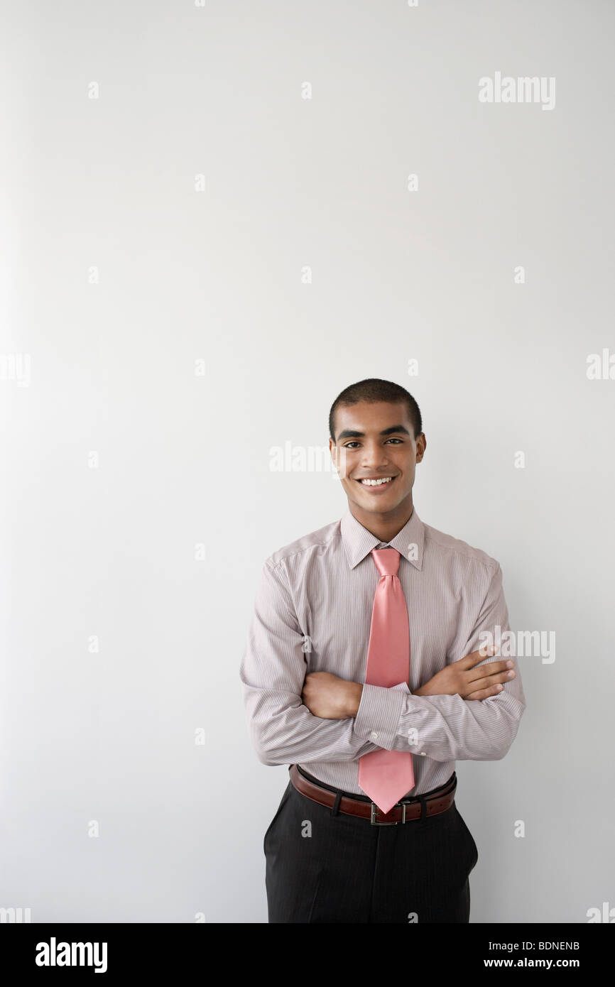 Business man standing against wall in office, portrait Stock Photo - Alamy