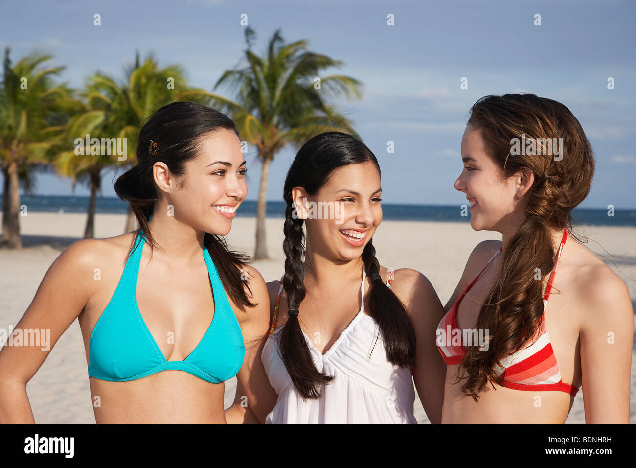 Three teenage girls (16-17) wearing bikinis, standing on beach, portrait  Stock Photo - Alamy