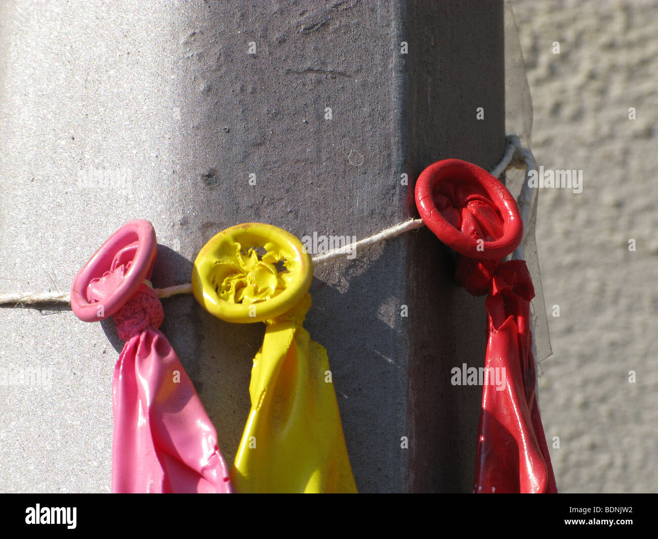 three burst balloons tied to lamp post outdoors in sun Stock Photo Alamy
