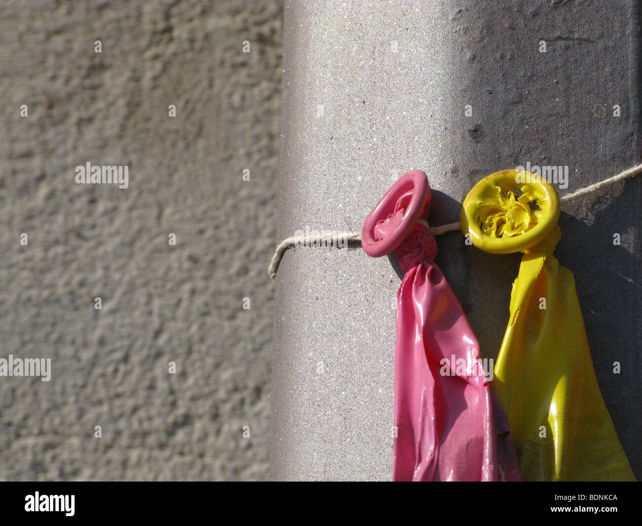 three burst balloons tied to lamp post outdoors in sun Stock Photo Alamy