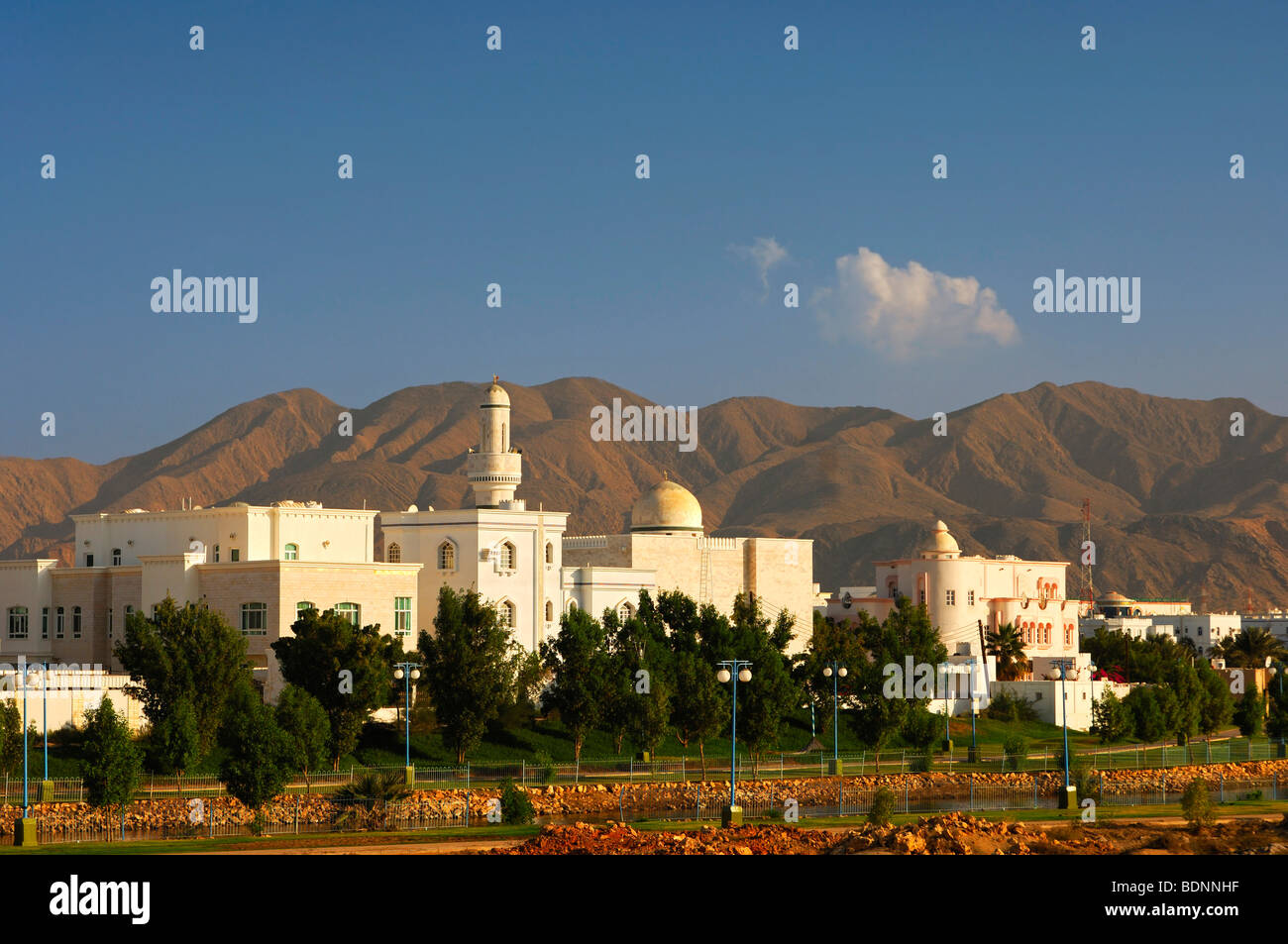 New housing estate with mosque and minaret, in front of stark mountains, Muscat, Sultanate of Oman, Middle East Stock Photo