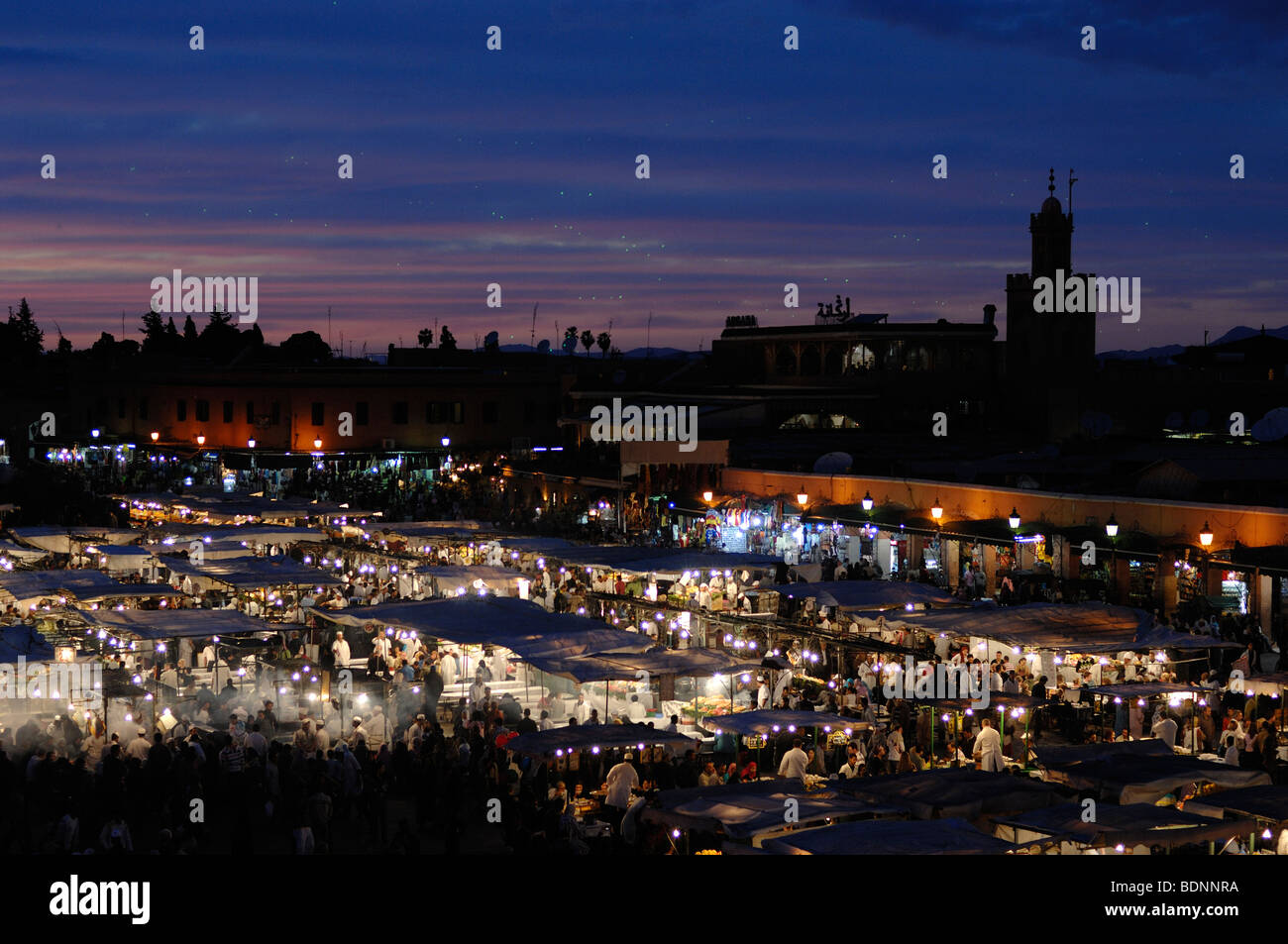 Panorama or Panoramic View over Lit Food Stalls on Djemaa El-Fna or Djemaa El Fna Square at Dusk, Evening or Early Night, Marrakesh, Morocco Stock Photo