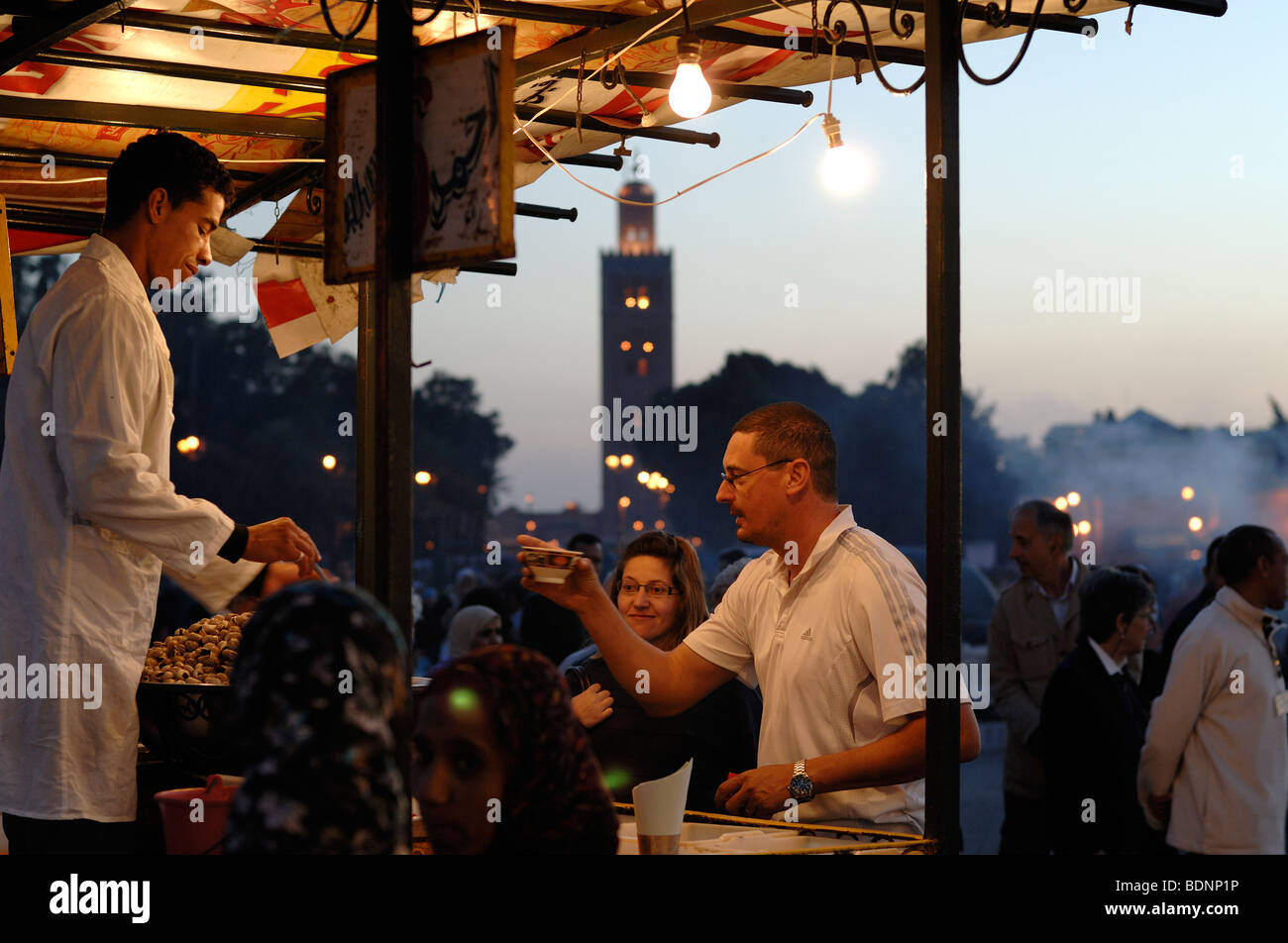 Food Stall & Tourists Buy Drinks at Dusk in Jemaa el-Fnaa, Djemaa El-Fna or Djemaa El Fna Square & Market Place Marrakesh, Morocco Stock Photo