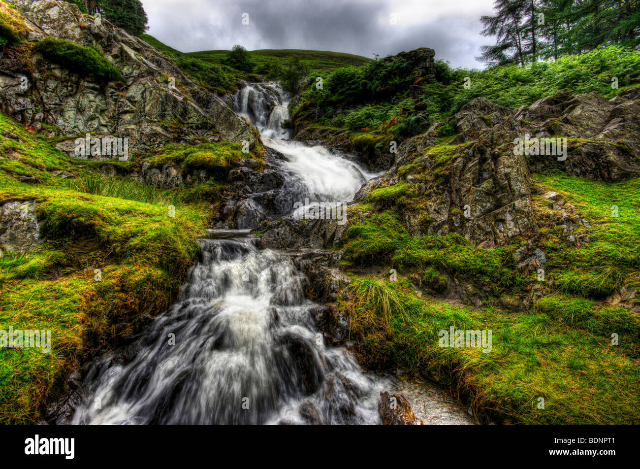 The majestic power of a long exposure shot of a waterfall in the lake district with water crashing over the rocks Stock Photo